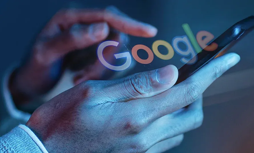 Person using a smartphone with the Google logo representing mobile search and online visibility for Long Island businesses.